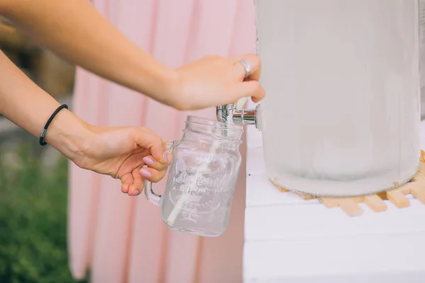 Female hands pouring lemonade — Stock Photo, Image