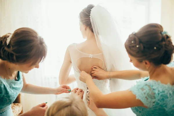 Bridesmaids helping lacing up dress — Stock Photo, Image