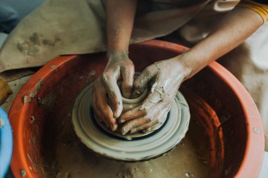 Potter çömlek çarkında seramik demlik yapıyor.