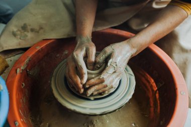Potter çömlek çarkında seramik demlik yapıyor.