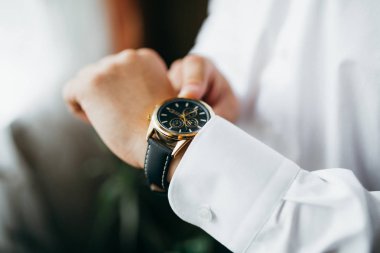 Damat Düğün için hazırlar, saate görünüyor