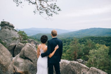 Şık şık mutlu esmer gelin ve arka planda bir güzel Dağları'nın muhteşem damat