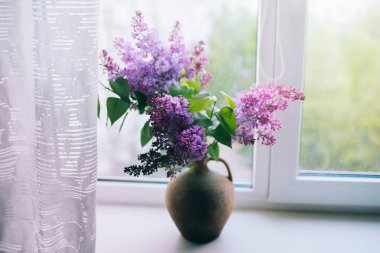 Leylak penceresinde bir sürahi içinde buket