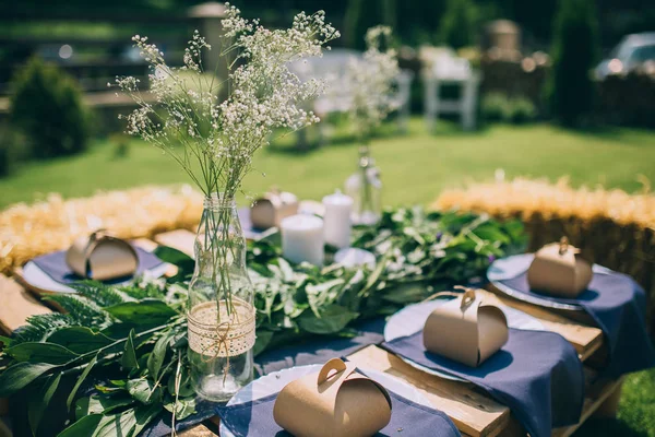 Wooden table setup for garden party or dinner reception.