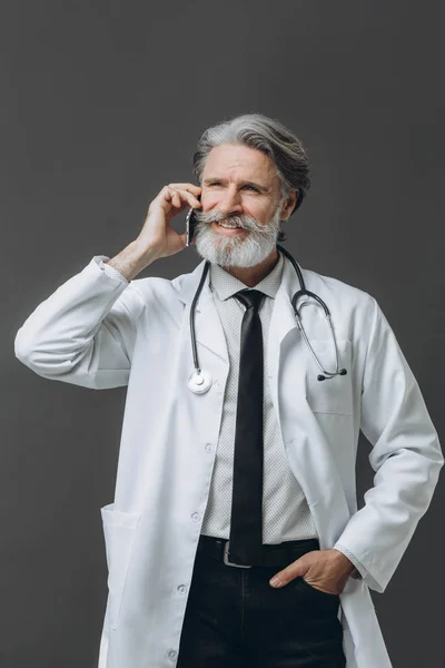 Médico sênior falando no telefone celular — Fotografia de Stock