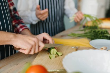 Oğlu ve kıdemli babası mutfakta yemek yapıyor..