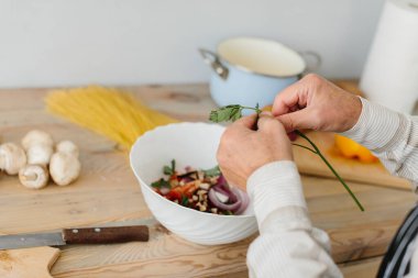 Büyük baba mutfakta salata hazırlıyor.