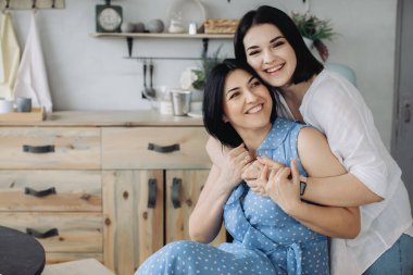 Anne ve kızları mutfakta birlikte eğleniyorlar. 