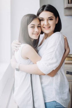 Kız kardeşler sarılıyor ve birlikte iyi vakit geçiriyorlar.