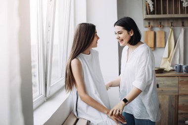 Kız kardeşler sohbet ediyor ve birlikte iyi vakit geçiriyorlar.