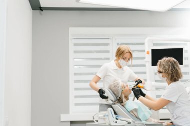 Diş doktorları hastayı muayene ediyor. Dişçiler çalışıyor..