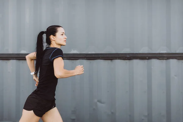 Sporty Pige Klædt Sort Løber Grå Væg Baggrund - Stock-foto