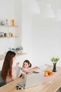 Anne ve kız mutfakta kahvaltı yaparken oyun oynuyorlar..