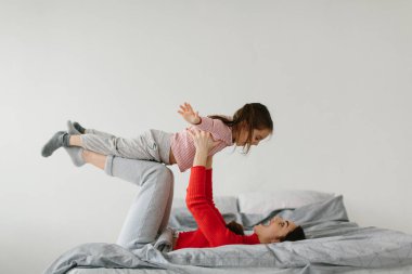 Sevgi dolu bir aile. Anne ve kızı oynuyorlar ve sarılıyorlar..