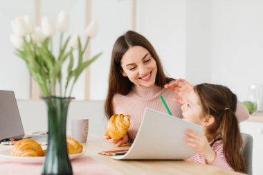 Anne ve kız mutfakta kahvaltı yaparken oyun oynuyorlar..