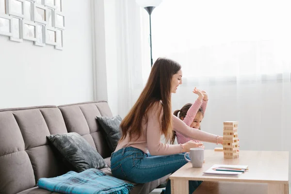 妈妈和女儿在客厅玩棋盘游戏 — 图库照片