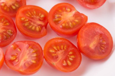 Beyaz bir tabağa dilimlenmiş kiraz domates