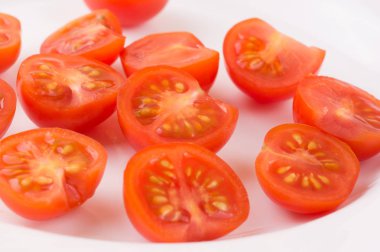 Beyaz bir tabağa dilimlenmiş kiraz domates