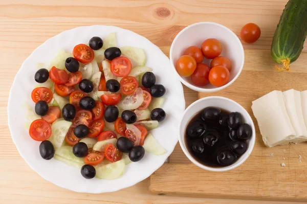 Ensalada griega con verduras, queso feta, aceitunas negras en proces —  Fotos de Stock