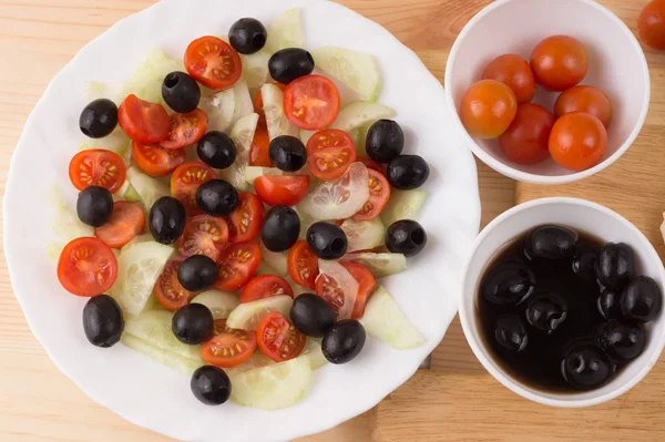 Ensalada griega con verduras, queso feta, aceitunas negras en proces —  Fotos de Stock