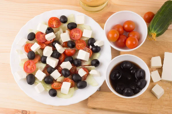 Ensalada griega con verduras, queso feta, aceitunas negras en proces —  Fotos de Stock