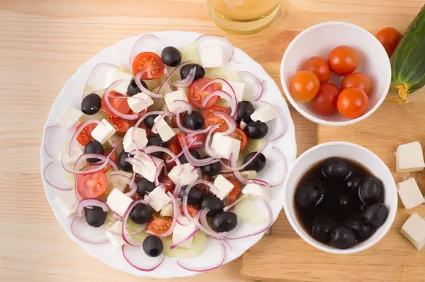Ensalada griega con verduras, queso feta, aceitunas negras en proces —  Fotos de Stock