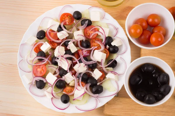 Ensalada griega con verduras, queso feta, aceitunas negras en proces —  Fotos de Stock