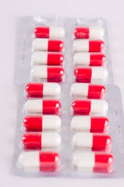 Beyaz ve kırmızı kapsül blister kutu içinde. İlaç tedavisi. H