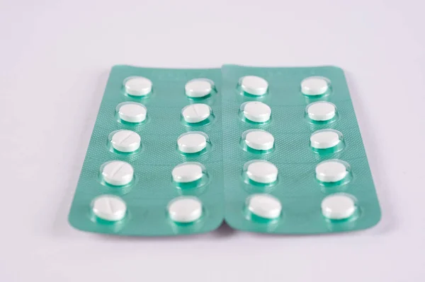白色药片, 药片在绿色水泡包装。药剂治疗 — 图库照片