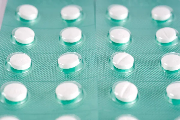 Vita tabletter, piller i gröna blisterförpackning. Medikament behandling — Stockfoto