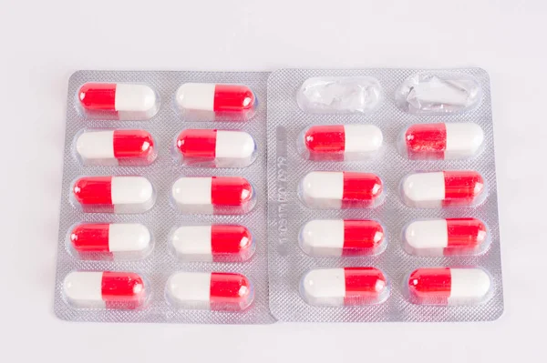 White and red capsules in  blister pack. Medicament treatment. H — Stock Photo, Image