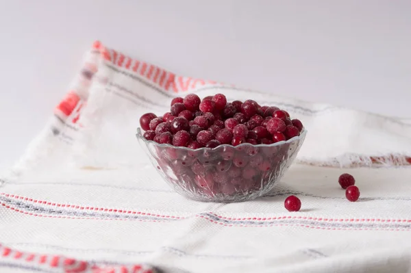 Bayas de arándano congeladas en un plato sobre un mantel blanco — Foto de Stock