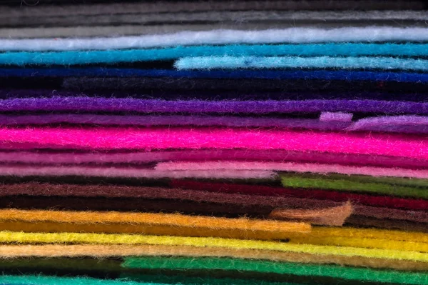 Una pila de fieltro acrílico colorido. Tejido macrofoto multicolor —  Fotos de Stock