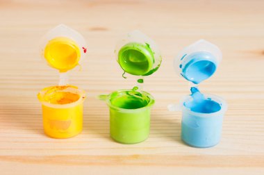 Ahşap masa üzerinde renkli Akrilik boyalar. Çocuğun sanat