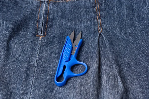 Jeans primo piano, cuciture, forbici. Interlacciare il tessuto con un — Foto Stock