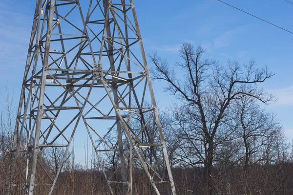 High voltage post at winter forest. High-voltage tower sky backg — Stock Photo, Image