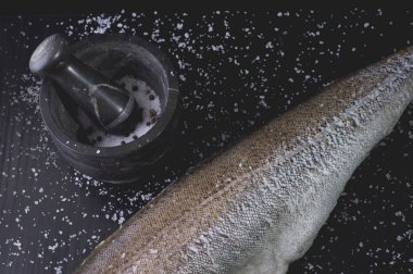 Beyaz domates ve bir siyah ahşap bac üzerinde mermer harç ile balık