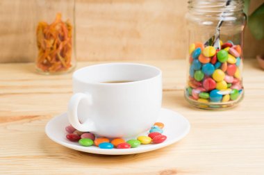 Kahve kupa, şeker ve bir tahta üzerinde bir kavanoza portakal kabuğu renkli 