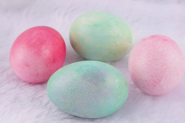 Quatre oeufs de Pâques peints multicolores sur lapin artificiel blanc — Photo