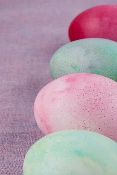 Quatre oeufs de Pâques peints multicolores nappe lilas. vacances — Photo