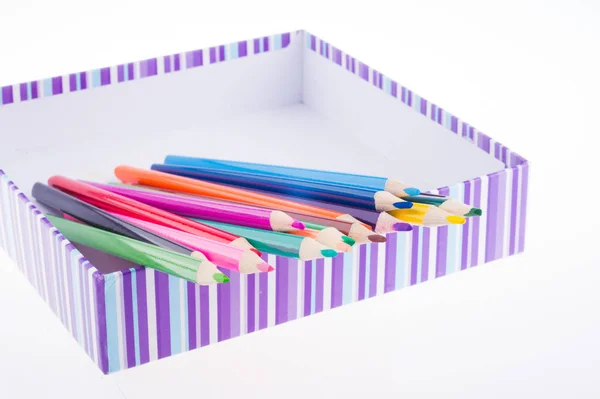 Composición con lápices de color en caja a rayas. concepto de regalo —  Fotos de Stock