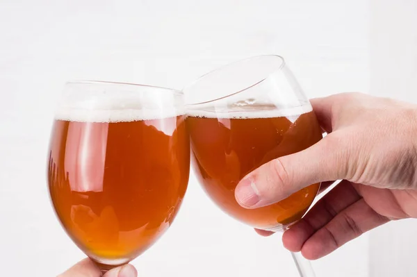 Deux mains tenant un verre de bière artisanale maison sur fond blanc — Photo