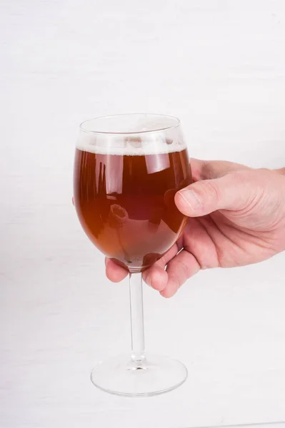 Männliche Hand hält ein Glas hausgemachtes Craft Beer auf weißem Backgr — Stockfoto