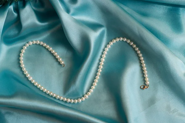Przebłysk naturalnych perełek perłowych naszyjnik na turkusowym jedwabiu — Zdjęcie stockowe