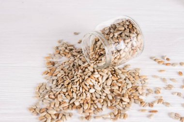 sunflower seeds in a jar  on white wooden background. vegetarian