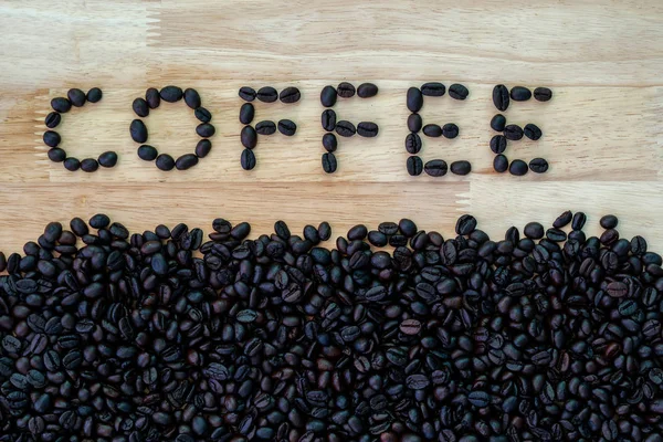 Gebrande koffiebonen op het hout. — Stockfoto