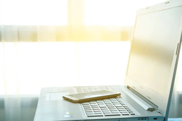 Computer and phone in sunshine. — Stock Photo, Image