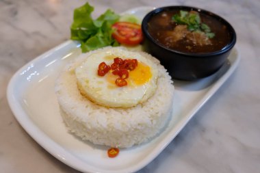 Sahanda yumurta kaynatın çorbası ile pirinç.