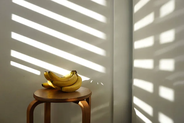 Bananas lie on a wooden chair in natural light. The concept of vegetarianism, veganism, raw food, healthy eating and diet.