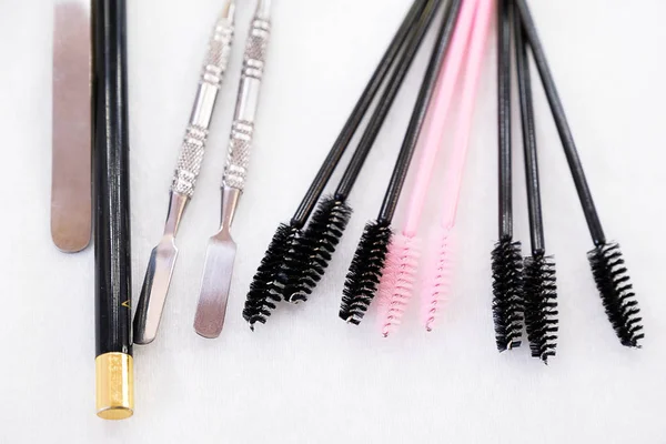 A set of brushes and pencil makeup artist for professional makeup in front of a mirror in a beauty salon, the concept of cosmetology, modeling and correction of the eyebrow line, self-care.